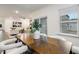 Dining area with modern wood table, white chairs, and sliding glass doors leading outside at 1116 Ciandra Barn Way, Apex, NC 27523