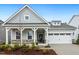 Charming home featuring a covered porch, two-car garage, and well-maintained landscaping at 1116 Ciandra Barn Way, Apex, NC 27523