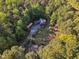 Scenic aerial view showcasing a two-story home, tennis court, and carport, all surrounded by verdant trees at 11209 Sedgefield Dr, Raleigh, NC 27613