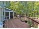 Large wooden back deck featuring a screened-in porch and views of the wooded backyard at 11209 Sedgefield Dr, Raleigh, NC 27613