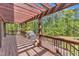 Inviting back deck with pergola, outdoor grill, and railing overlooking lush greenery at 11209 Sedgefield Dr, Raleigh, NC 27613