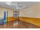 Spacious bedroom featuring light colored walls, hardwood floors, paneled walls, and a fan at 11209 Sedgefield Dr, Raleigh, NC 27613