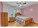 Cozy bedroom with light wood floors and decorative wallpaper, featuring a ceiling fan at 11209 Sedgefield Dr, Raleigh, NC 27613