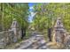 Gated driveway entrance flanked by stone pillars and lion statues, leading to the house at 11209 Sedgefield Dr, Raleigh, NC 27613