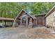 Charming home featuring a covered entryway with stone accents and statues, surrounded by a gravel driveway at 11209 Sedgefield Dr, Raleigh, NC 27613