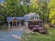 Stunning home featuring stone accents, dual-entry front doors, and a spacious deck, surrounded by lush greenery at 11209 Sedgefield Dr, Raleigh, NC 27613