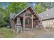 Charming home featuring a covered entryway with stone accents and statues, surrounded by a gravel driveway at 11209 Sedgefield Dr, Raleigh, NC 27613