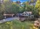 Two-story home with a pergola-covered deck and stone accents near a carport and gazebo, surrounded by lush greenery at 11209 Sedgefield Dr, Raleigh, NC 27613