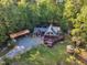 Two-story home surrounded by lush trees, featuring a deck, carport, and gazebo, offering privacy and tranquility at 11209 Sedgefield Dr, Raleigh, NC 27613