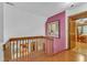 Second floor hallway with wood railing, a colorful accent wall, and hardwood floors at 11209 Sedgefield Dr, Raleigh, NC 27613