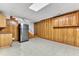 Basement kitchenette features cabinets, a refrigerator, and convenient access to the stairs at 11209 Sedgefield Dr, Raleigh, NC 27613