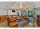 Comfortable living room featuring a wet bar, large leather couch, chandelier, and natural light at 11209 Sedgefield Dr, Raleigh, NC 27613