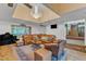 Cozy living room featuring a chandelier, leather couch, built-in wet bar, and views of the outdoors at 11209 Sedgefield Dr, Raleigh, NC 27613
