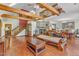 Open-concept living room featuring wood beams, a stone fireplace, and a comfortable seating area at 11209 Sedgefield Dr, Raleigh, NC 27613