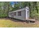 Exterior view of an outbuilding with windows, a door, and wood siding, suitable for various purposes at 11209 Sedgefield Dr, Raleigh, NC 27613