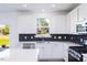 Bright kitchen features white cabinetry, stainless steel appliances, and a window overlooking greenery at 113 Sepals Pl, Wendell, NC 27591