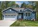 Charming exterior of a blue, single-story home with a manicured lawn and an attached garage at 115 Buckskin Dr, Louisburg, NC 27549