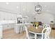 Open floor plan combining a modern kitchen with white cabinets and island, adjacent dining area, and Gathering room at 115 Buckskin Dr, Louisburg, NC 27549