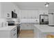 Modern kitchen with bright white cabinets, subway tile backsplash, stainless appliances, and luxury vinyl plank flooring at 115 Buckskin Dr, Louisburg, NC 27549