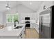 Modern kitchen boasts white cabinets, stainless appliances, island with seating, and lots of light at 115 Buckskin Dr, Louisburg, NC 27549
