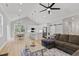 Open-concept living room with high ceilings, ceiling fan, dining area, and modern white kitchen at 115 Buckskin Dr, Louisburg, NC 27549