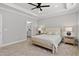 Relaxing main bedroom showcasing tray ceilings and ensuite bath with dual nightstands and plush bedding at 115 Buckskin Dr, Louisburg, NC 27549