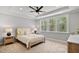 Serene main bedroom with large windows, a tray ceiling and neutral decor for a relaxing ambiance at 115 Buckskin Dr, Louisburg, NC 27549