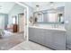 Bathroom featuring double sink vanity, light gray cabinets, and doorway leading back to the bedroom at 117 Buena Vista Dr, Cary, NC 27513