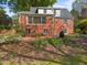 Brick home featuring a brick patio and a lush landscaped garden with flowers at 119 Montgomery St, Raleigh, NC 27607