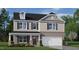 Two-story home with brick and siding exterior, a covered porch, and an attached two-car garage at 1204 Pavo Path, Wendell, NC 27591