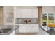 Open kitchen with white cabinets, gray backsplash, and granite countertops at 1204 Pavo Path, Wendell, NC 27591