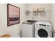 Functional laundry room with modern washer, dryer, and storage shelves at 1204 Pavo Path, Wendell, NC 27591