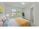 Sunlit bedroom with a large window, a cozy bed with soft pillows, and a view of the outdoors at 1209 Huffington Oak Dr, Willow Springs, NC 27592