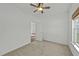 A carpeted bedroom features a ceiling fan and an open door, offering a glimpse into an adjoining room at 1209 Huffington Oak Dr, Willow Springs, NC 27592