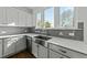 Farmhouse sink and window in kitchen with gray backsplash, stainless steel faucet, and white cabinetry at 1209 Huffington Oak Dr, Willow Springs, NC 27592