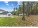 Large backyard with a combination of lawn, outbuildings, and mature trees at 124 Maluli Dr, Oxford, NC 27565