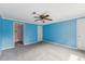 Bedroom boasts neutral carpet and blue walls, complemented by ceiling fan and two entryways at 124 Maluli Dr, Oxford, NC 27565