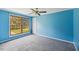 Bedroom with neutral carpet, blue walls, and large window offering natural light and forest views at 124 Maluli Dr, Oxford, NC 27565