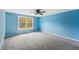 Bedroom with neutral carpet, a large window, and blue walls, providing natural light and a calming atmosphere at 124 Maluli Dr, Oxford, NC 27565