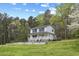 Charming two-story home with a wraparound porch, complemented by a well-manicured front yard and lush green trees at 124 Maluli Dr, Oxford, NC 27565