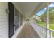 Inviting covered front porch with wood flooring and white railing overlooking the yard at 124 Maluli Dr, Oxford, NC 27565