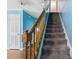 Carpeted staircase with wooden railing, offers access to the upper level of the home and blends comfort with classic design at 124 Maluli Dr, Oxford, NC 27565