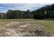 Open backyard with scattered bare patches and tree line at 1278 Valley Ct, Zebulon, NC 27597