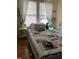 Sunlit bedroom with a bed, side table, and a serene window view at 1308 Wake Forest Rd, Raleigh, NC 27604