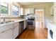 Kitchen with white cabinets, stainless appliances, and view to the adjoining room at 1308 Wake Forest Rd, Raleigh, NC 27604