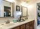 Bathroom featuring double sinks, framed mirrors, and a walk-in closet, offering both functionality and ample storage at 132 Crystal Pl, Benson, NC 27504