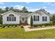 Charming home with a brick-lined entryway, a decorative wreath, and rocking chairs on a covered front porch at 132 Crystal Pl, Benson, NC 27504