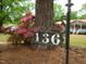 A decorative address sign reading '136' sits beneath a tree, with a glimpse of the house in the background at 136 Scramble Rd, Erwin, NC 28339