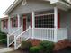 Inviting front porch with white railings and red accents, offering a cozy outdoor space at 136 Scramble Rd, Erwin, NC 28339