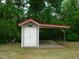 Exterior view of a shed with a red roof and covered area for storage at 136 Scramble Rd, Erwin, NC 28339